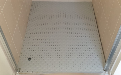 Custom aluminium shower base insert converting standard shower recess into a slip-resistant, accessible entry